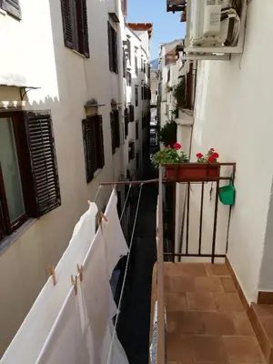 an alley with white buildings and a balcony at Casa Annuccia ai Quattro Canti di Città in Palermo