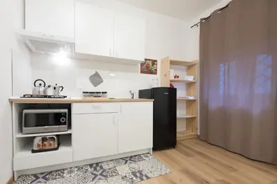 a kitchen with white cabinets and a black refrigerator at Casa Annuccia ai Quattro Canti di Città in Palermo
