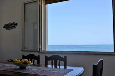 a dining room table with a view of the ocean at Sea Front in Carini