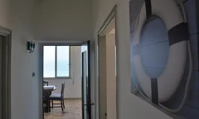 a hallway with a room with a table and a painting on the wall at Sea Front in Carini