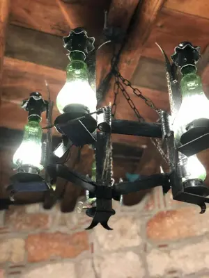 a black chandelier hanging from a ceiling at La casa del Cedro in Palermo