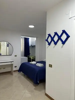 a bedroom with a bed and a window with blue curtains at VENTO di MARE in Palermo