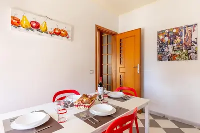 a dining room with a white table and red chairs at Residenza del Duca - Casteldaccia 2 camere in Casteldaccia