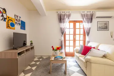 a living room with a couch and a tv at Residenza del Duca - Casteldaccia 2 camere in Casteldaccia