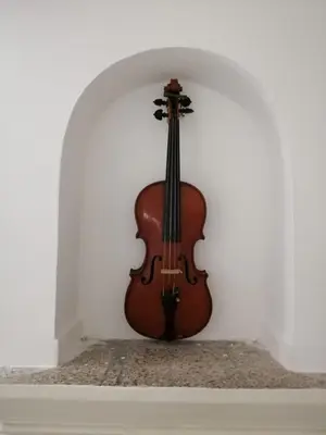 a violin is leaning against a white wall at Opera Boutique Rooms in Monreale