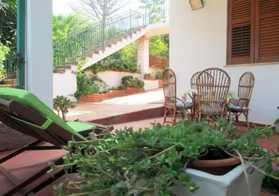 a patio with chairs and a table and a plant at Casa Vacanza nell'Orto in Termini Imerese