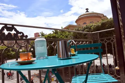 a table on a balcony with a tea set on it at Teatro Massimo City Center Apartments in Palermo