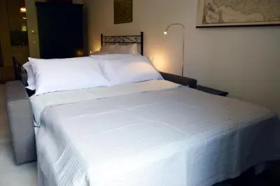 a white bed with white sheets and pillows at Teatro Massimo City Center Apartments in Palermo