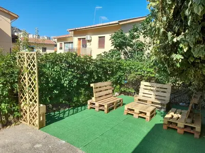 two chairs and a bench on a green lawn at Lisetta's house in Monreale