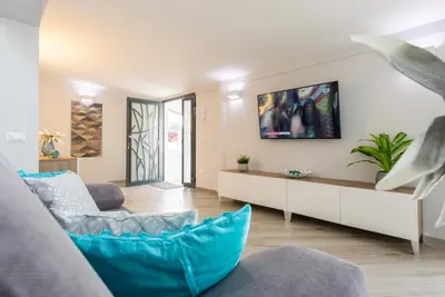 a living room with a couch and a tv on a wall at villa Roby in Trappeto