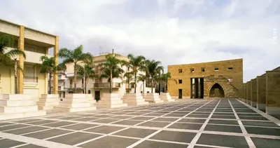 an empty parking lot with palm trees and buildings at Gibellina Home in Nuova Gibellina