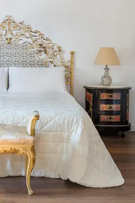 a bedroom with a bed and a night stand with a lamp at B&B Villa Liberty sul Mare by Wonderful Italy in Palermo
