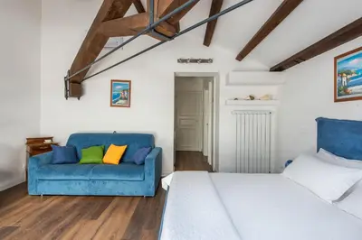 a bedroom with a bed and a blue couch at B&B Villa Liberty sul Mare by Wonderful Italy in Palermo