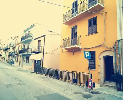 a yellow building with a parking sign on a street at La Dimora Di Segesta in Calatafimi