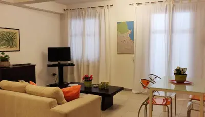 a living room with a couch and a table at Appartamento a due passi dal mare in Palermo