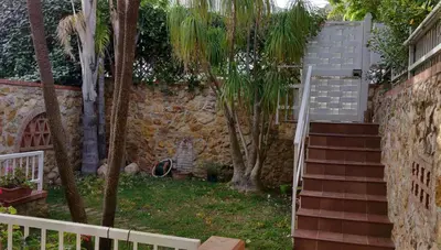 a stairway with palm trees and a stone wall at Appartamento a due passi dal mare in Palermo