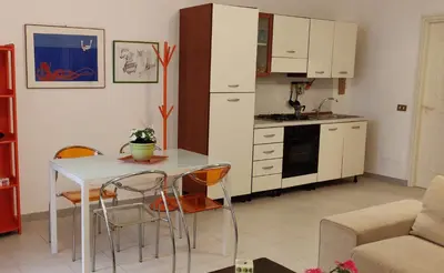 a kitchen with a table and chairs in a room at Appartamento a due passi dal mare in Palermo