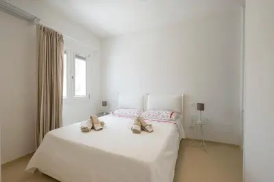 a white bedroom with a bed with shoes on it at Villa Acquamarina sul mare in San Vito lo Capo
