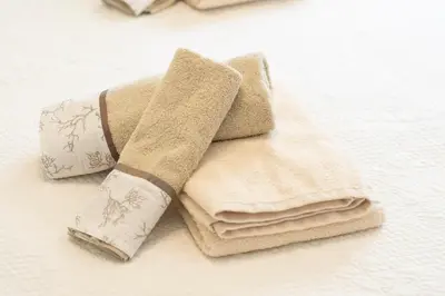 a pile of towels sitting on top of a bed at Villa Acquamarina sul mare in San Vito lo Capo