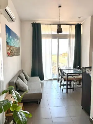 a kitchen and living room with a couch and a table at I Mori Apartment in Palermo