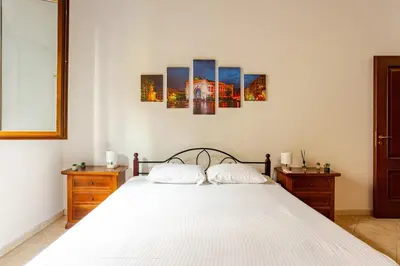 a bedroom with a bed with four paintings on the wall at Nino's house in Palermo