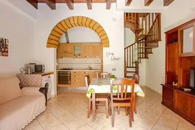 a living room with a table and a kitchen at Nino's house in Palermo