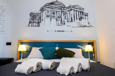 a bed with towels on it with a drawing on the wall at b&b Pirriera in Bagheria