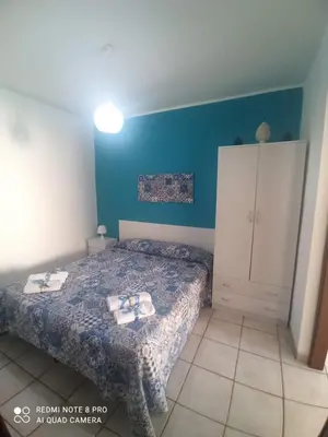 a small bedroom with a bed and a cabinet at Sicilia Bedda isolotto in Isola delle Femmine