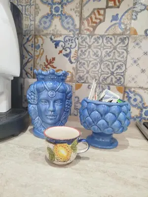 three blue vases and a bowl on a table at Sicilia Bedda isolotto in Isola delle Femmine