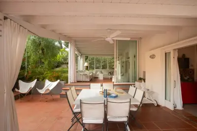 a dining room with a white table and chairs at La casa del Rinoceronte - Scopello, con accesso diretto al mare in Castellammare del Golfo