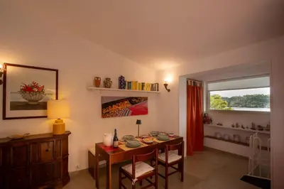 a dining room with a table and a window at La casa del Rinoceronte - Scopello, con accesso diretto al mare in Castellammare del Golfo