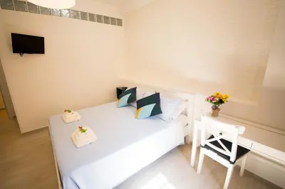 a small bedroom with a white bed and a table at La Balestra B&B in Balestrate