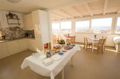 a kitchen and dining room with a table with food on it at La Balestra B&B in Balestrate