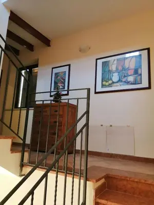 a staircase in a house with a painting on the wall at Baglio delle Rondini in Bagheria