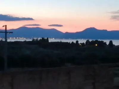 a sunset with mountains in the background at Baglio delle Rondini in Bagheria