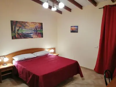 a bedroom with a red bed with a red curtain at Baglio delle Rondini in Bagheria
