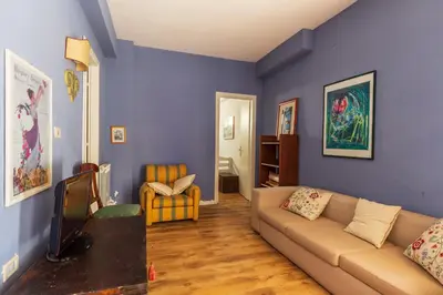 a living room with a couch and a blue wall at Domus Sicily - Villa Conca d'Oro with Pool in Palermo
