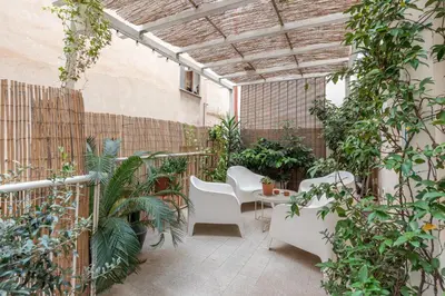 a patio with white chairs and plants in a building at Sant'Agostino Apartment with Terrace by Wonderful Italy in Palermo