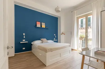 a blue bedroom with a bed and a blue wall at Sant'Agostino Apartment with Terrace by Wonderful Italy in Palermo