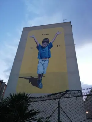 a young boy jumping in the air on a billboard at Casuzza Ballarò in Palermo