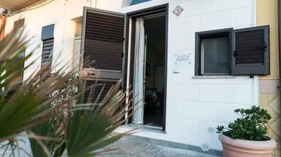 a building with black shutters and a window at Il Nido del Gabbiano in Bagheria