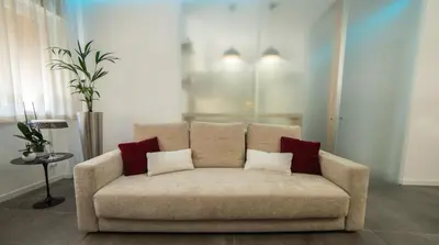 a couch with three pillows on it in a living room at Maison Heloise in Palermo