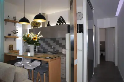 a kitchen with a counter and stools in a room at Maison Heloise in Palermo