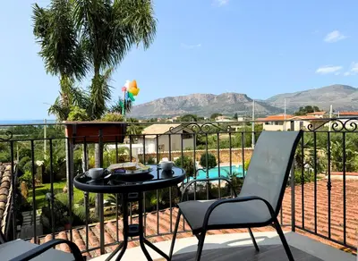 a patio with a table and chairs on a balcony at Case Vacanza Zeus in Trappeto