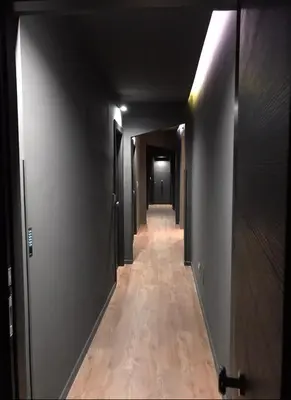 a hallway with a long corridor with doors and wooden floors at Residenza del Castillo in Palermo