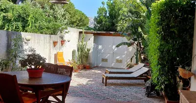 a patio with a table and chairs and a garage at Villetta a due passi dal mare in Palermo