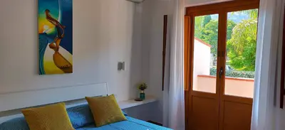 a bedroom with a blue bed and a window at Villetta a due passi dal mare in Palermo