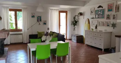 a living room with a table and green chairs at Villetta a due passi dal mare in Palermo