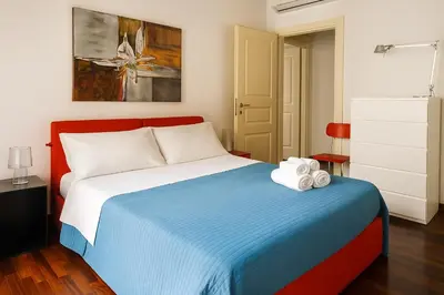 a bedroom with a bed with a blue blanket at Cassàri Suite in Palermo
