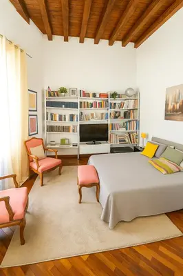 a bedroom with a bed and two chairs and a tv at Cassàri Suite in Palermo